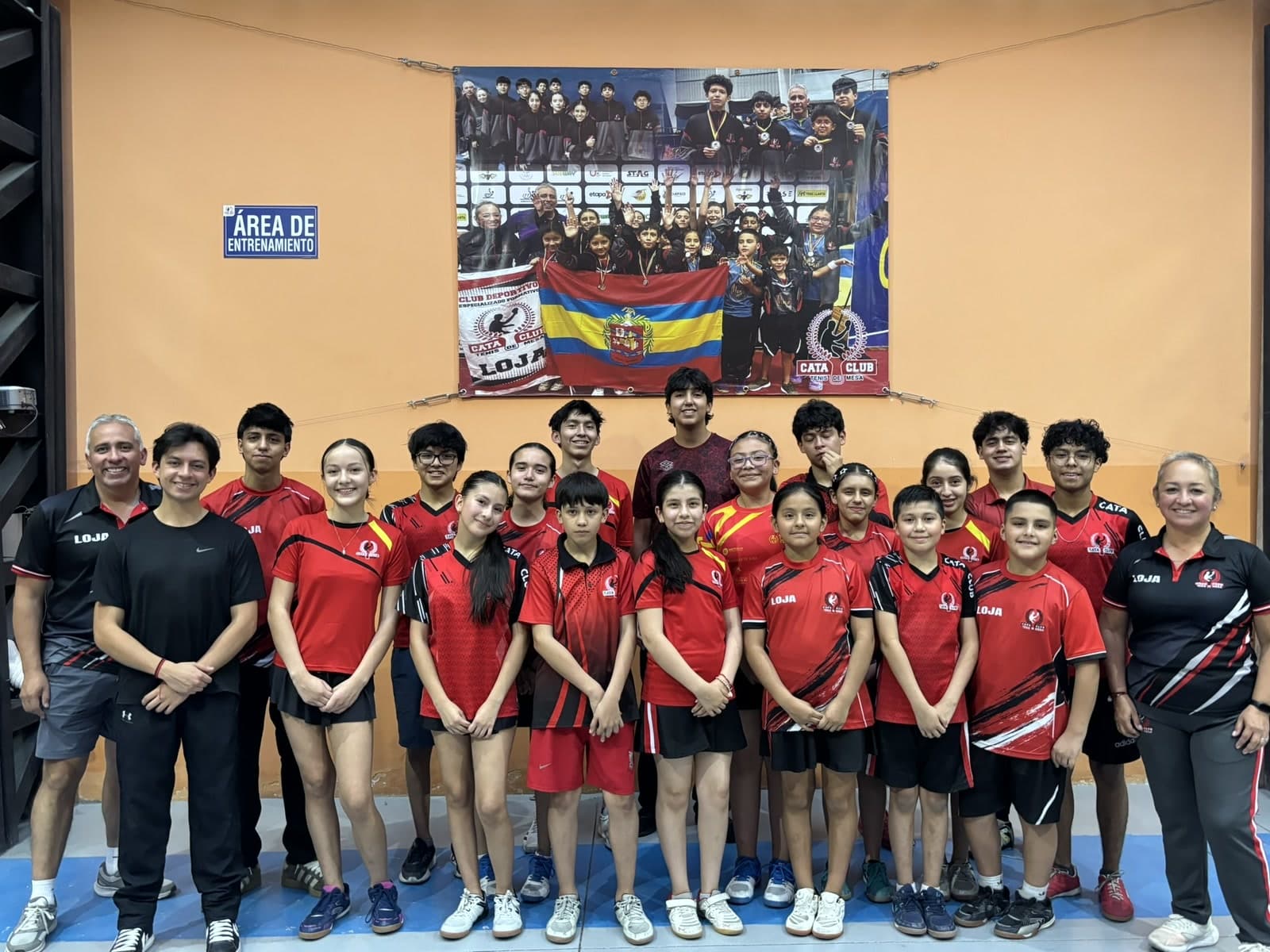 Equipo de Cata Club con la camiseta del club, junto a sus entrenadores, en la sala de entrenamiento.